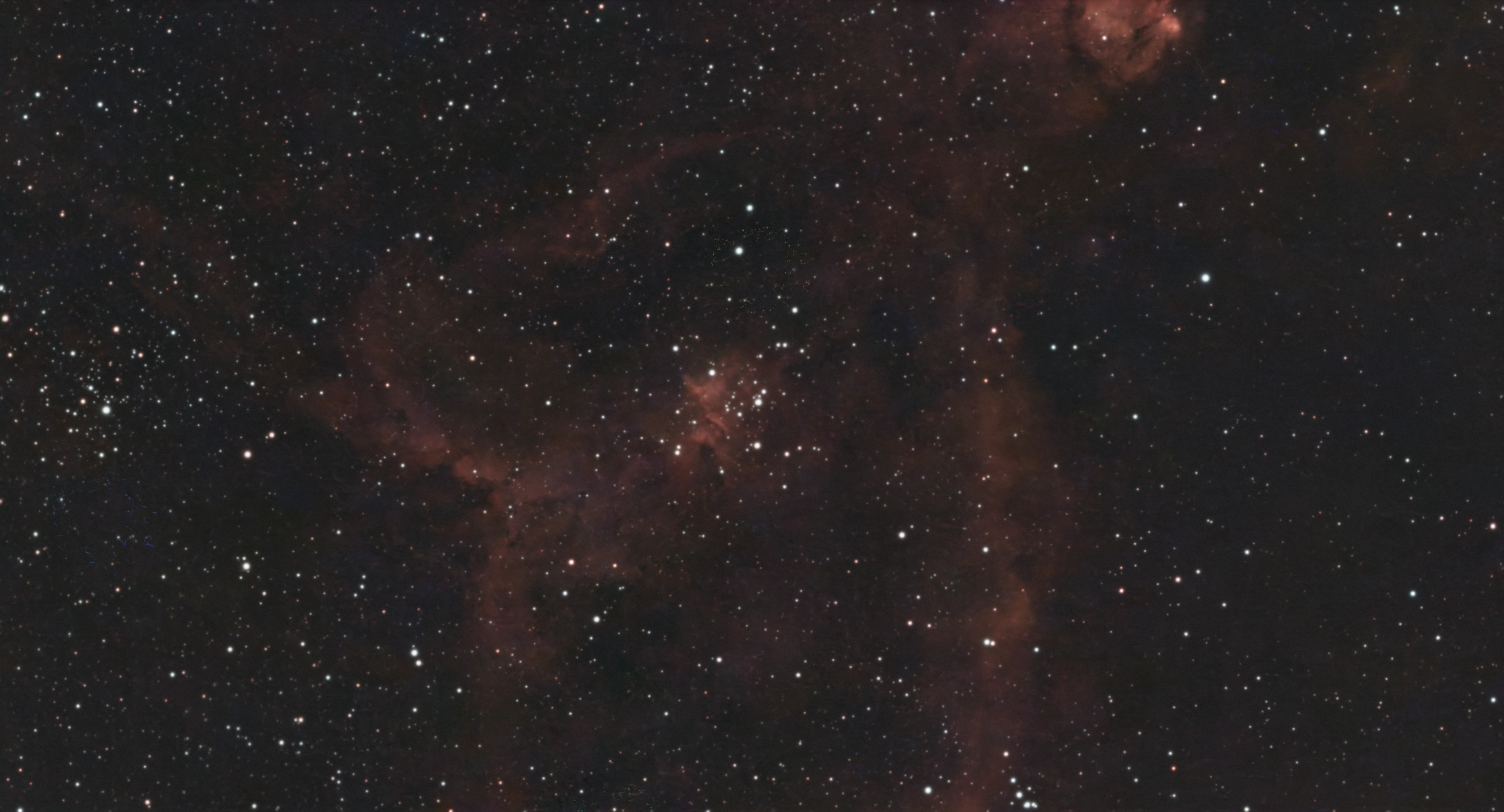 Red clouds and dark dust lanes of the Heart Nebula around a bright central star cluster